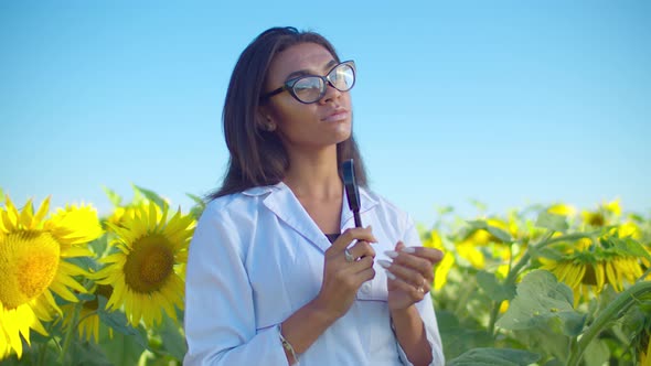 Pensive Black Woman Agronomist in Sunflower Field alt