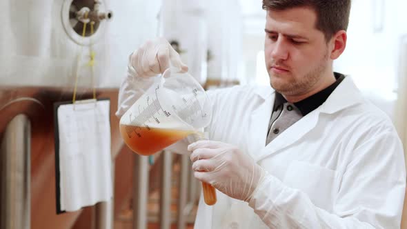 A Technologist at a Brewery Pours Beer Into a Test Tube