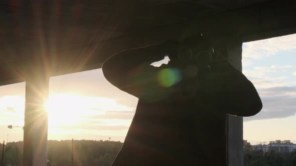 Unrecognizable Bearded Man Puts on Yellow Hood and Gas Mask and Breath Sun Shines Into Camera alt