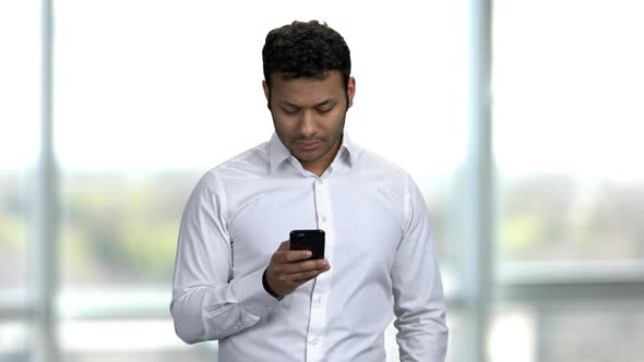 Young Indian Worker Insensibly Taking Photo of His Coworker in Office alt