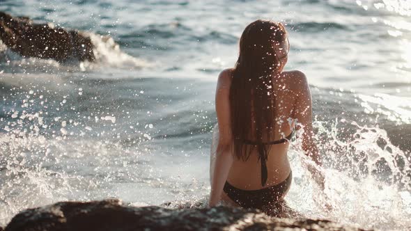 Woman is Sitting on Rock Os Seashore Waves Crashing alt