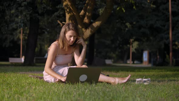 Woman Works Remotely In Park. alt