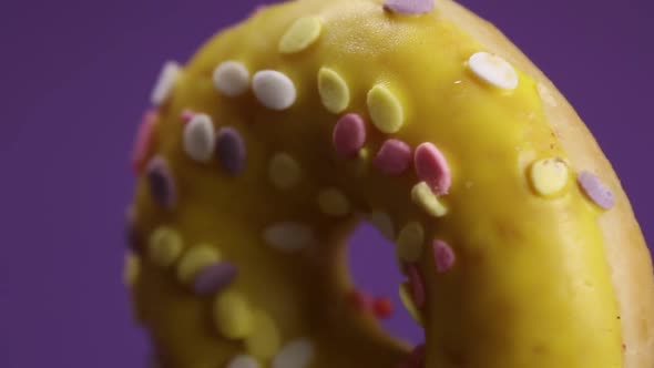 Donut with Yellow Icing on a Lilac Background