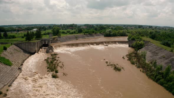 Aerial Drone View. River Water Move Down From with a Water Filled Dam After Heavy Floods and Rains. alt