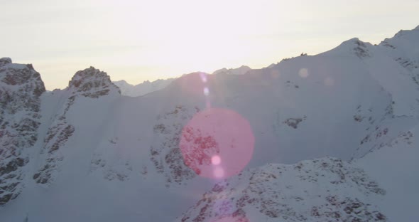 Aerial helicopter shot, tilt down to see steam rising from power plant, cars pass on highway, snow i alt
