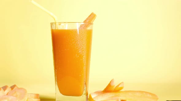 Healthy smoothie carrot juice vegetable cocktail tube on yellow background alt