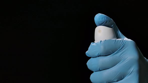 A Hand in a Protective Glove Sprays a Disinfecting Aerosol Spray. Prevention of COVID 19 and the alt