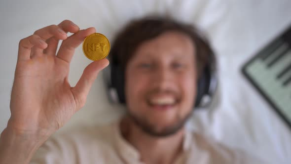 Woman a Music DJ Holds an NFT Coin in Her Hand alt