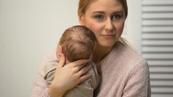 Young Female Holding Healthy Newborn Baby in Arms, Loving and Tender Mommy alt