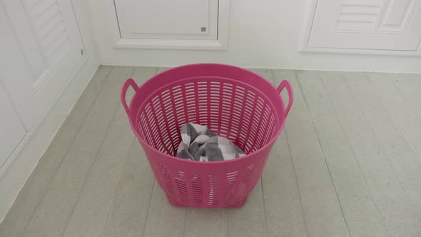 Slow Motion of Clothes Pants Filling Into a Laundry Basket on a Floor alt