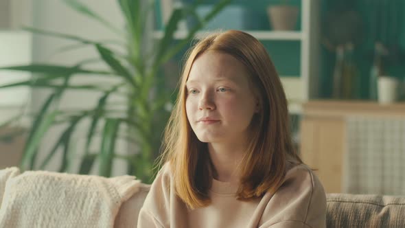 Portrait of a Sad Depressed Redhaired Teenage Girl with Sad Eyes alt