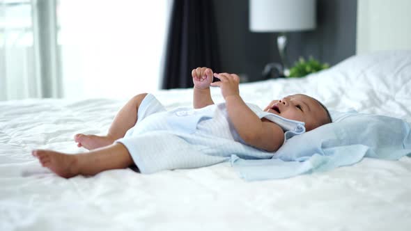 little cheerful baby move hands and legs on a bed
