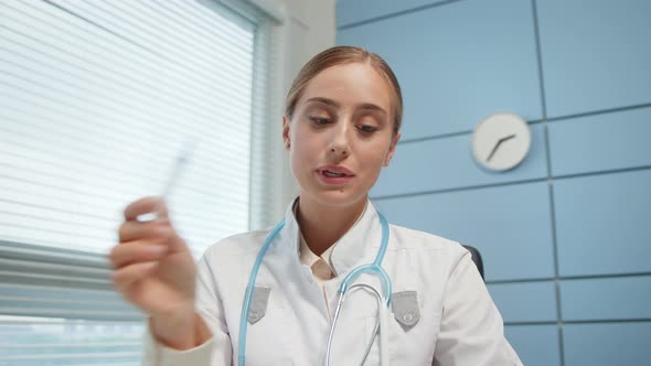 Blonde lady medical nurse blogger in white coat fills syringe alt