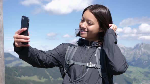 Female Hiker Taking Selfie on Scenic Overlook in Switzerland Mountains alt