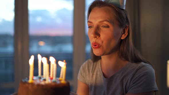 Happy Excited Woman Making Cherished Wish and Blowing Candles on Holiday Cake Celebrating Birthday alt