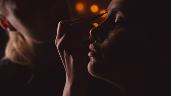 Makeup Artist Working in a Dark Studio alt