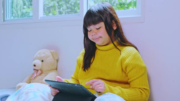 Asian girls study online and watch the tablet at home