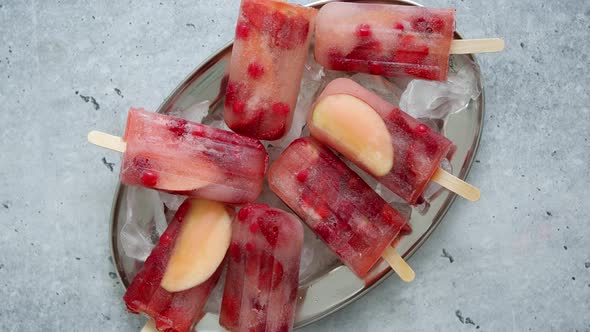 Homemade Raspberry, Strawberry, Apple and Currant Popsicles on Metal Plate with Ice Assorted Berries alt