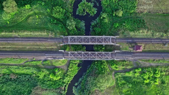 Railway Bridge Among Green Meadows Over a Small River in the Countryside alt