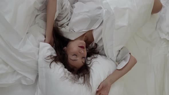 Young Attractive Woman Is Waking Up in Her Bed at Morning Time Top View on Lady alt