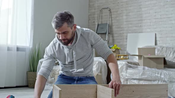 Man Assembling Wooden Furniture alt