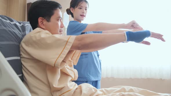 Asian female Physiotherapist working with patient in clinic doing arm stretching exercises alt