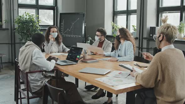 Business Partners in Masks Having Meeting in Office alt