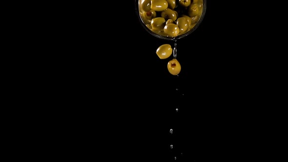 Marinade and Green Olives Pour Down From Tin Can on Black alt