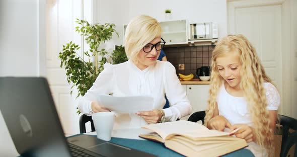 Mother and Daughter Hugging Near Laptop