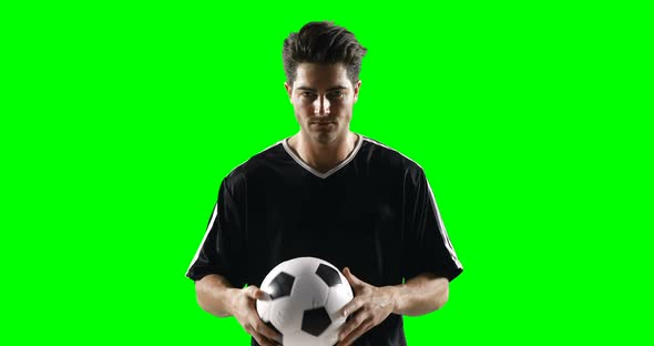 Football player holding a football against green screen alt