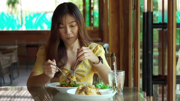 young woman eating spaghetti food in restaurant