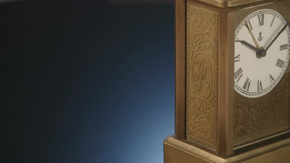 Antique wooden clock on a black shiny surface alt