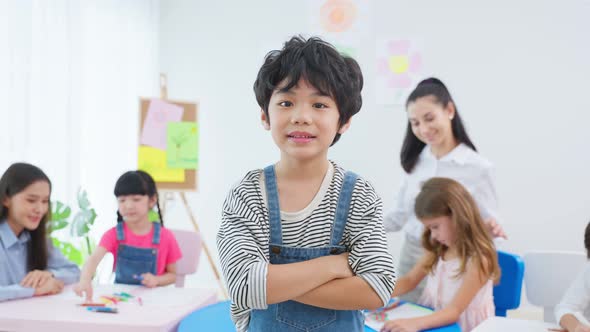 Portrait of Asian kid boy student stand with happiness in class room. alt