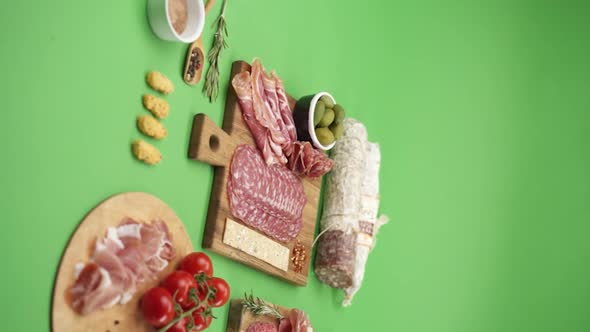 Vertical video, Close-up: cold cuts, salami, prosciutto, jamon, cherry tomatoes, sliced ​​sausage alt