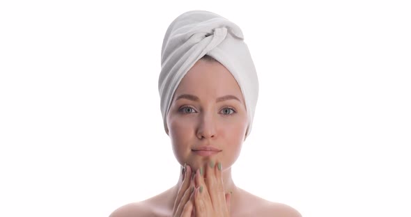 Portrait of a Young Beautiful European Woman with a White Towel on Her Head Touching Her Face Along