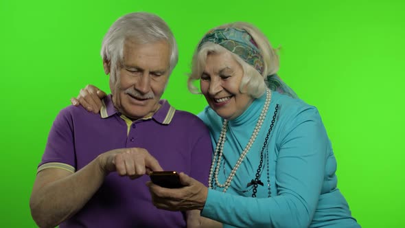 Mature Senior Old Couple Grandparents Enjoy Online Shopping on Mobile Phone alt