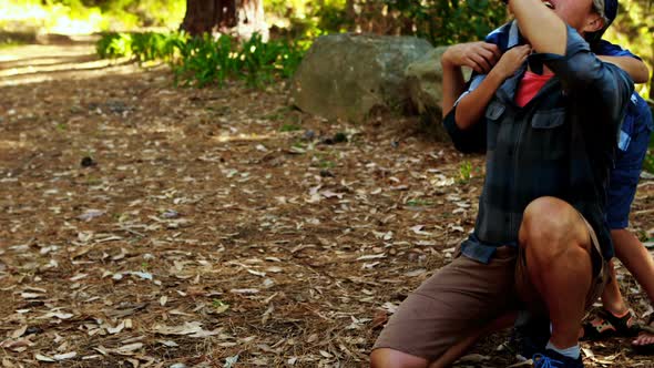 Father and son looking at nature in the park alt