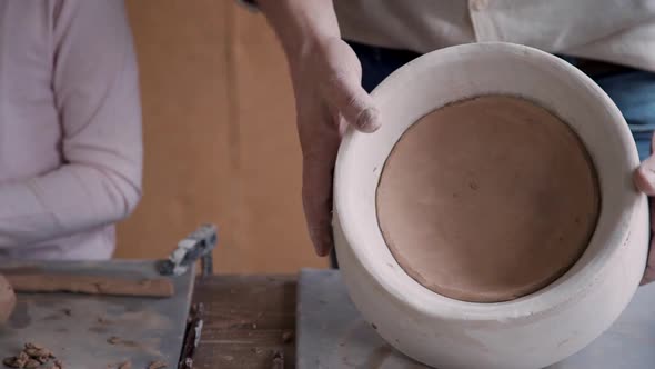 Potter Man Molding Wet Clay in Craft Studio Room