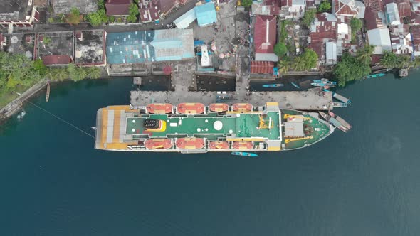 Aerial: flying over passenger ship Pelni in Bandaneira harbor Indonesia alt