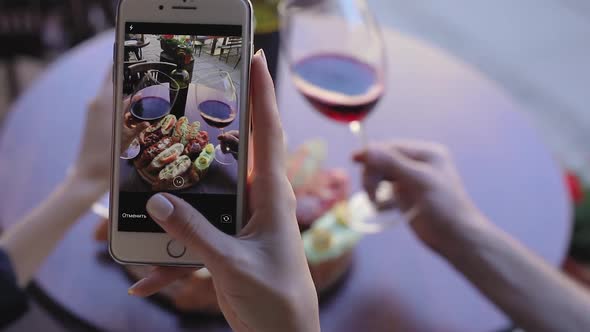 Closeup Woman Taking Photos Of Food And Wine In Restaurant alt