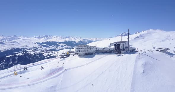 AERIAL: Flight Over Ski Resort in Swiss Alps Mountains LAAX Full with White Snow on Beautiful Sunndy alt