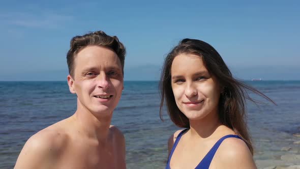 Summer Vacation in Coronavirus Epidemic. Couple on Beach with Sunburn in Shape of Face Mask.