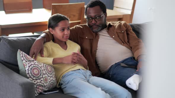 Positive father and daughter talking on the sofa alt