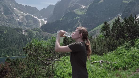 Young Girl Drinking Water After Climbing the Mountains
