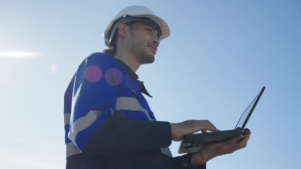 Asian technician inspection solar cell panels field of on roof top factory. alt