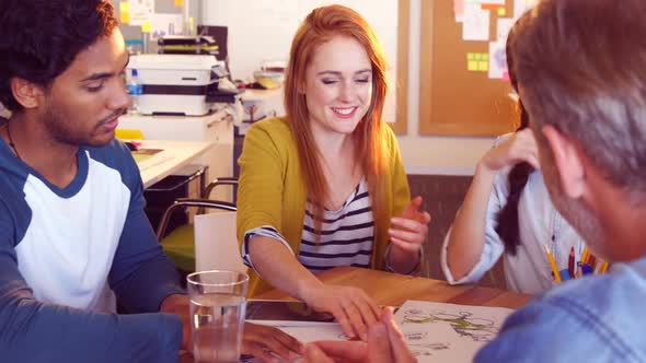 Business colleagues discussing over a document alt