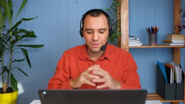 Young Man in Headset with Microphone Holding Online Meeting Conversation