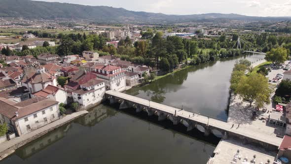 Aerial forward view of river with its Romanic bridge in city. Chaves. Portugal alt