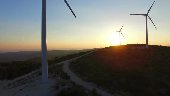 Aerial view from bottom to top of white wind turbines alt
