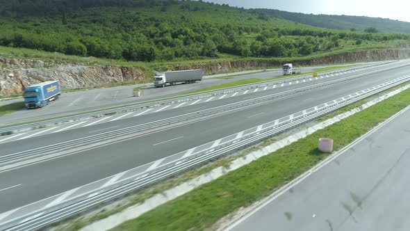Drone View of Big Cargo Trucks on Highway Pullout in Summer Day alt